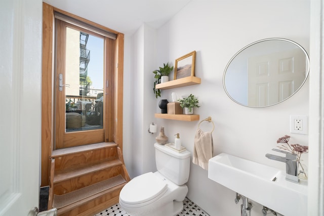 half bathroom featuring toilet and a sink