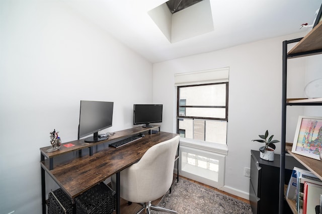 home office with baseboards and wood finished floors