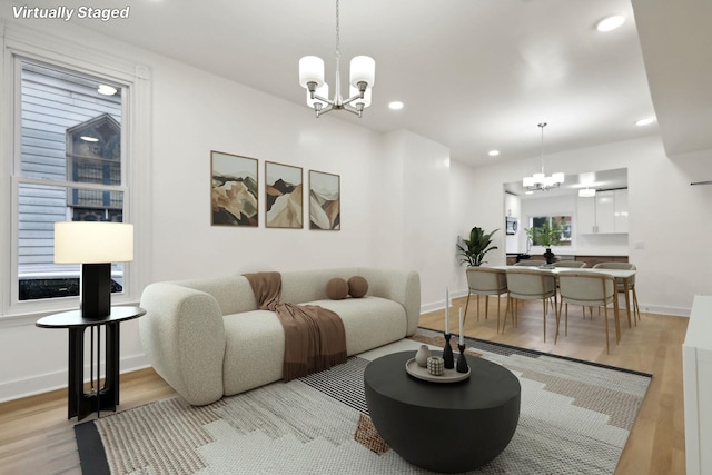 living room featuring light hardwood / wood-style flooring and a notable chandelier