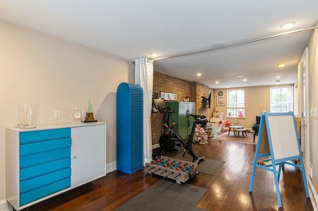 miscellaneous room featuring brick wall, recessed lighting, and wood finished floors