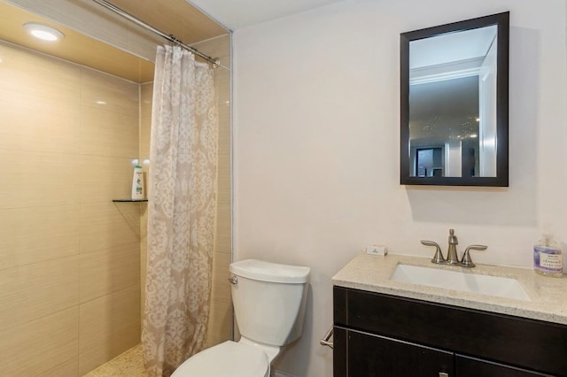 bathroom with vanity, toilet, and tiled shower