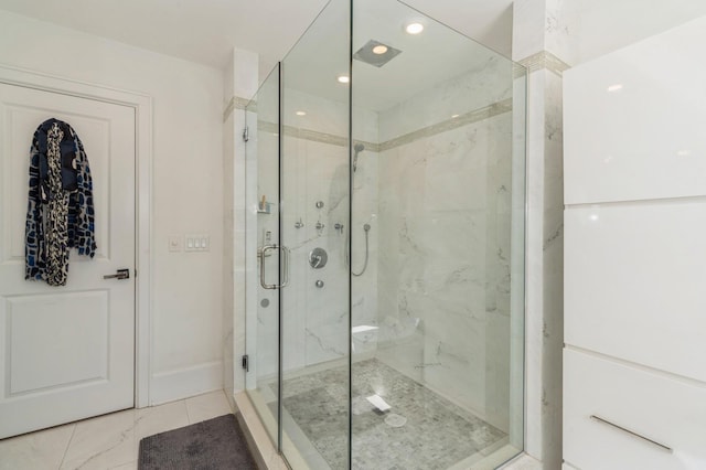 full bathroom featuring baseboards, a marble finish shower, and tile patterned flooring