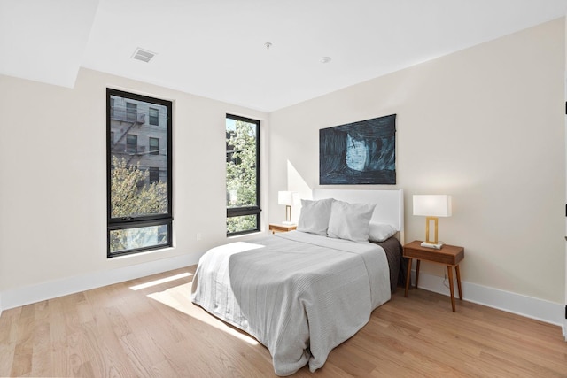 bedroom featuring light wood-style floors and baseboards