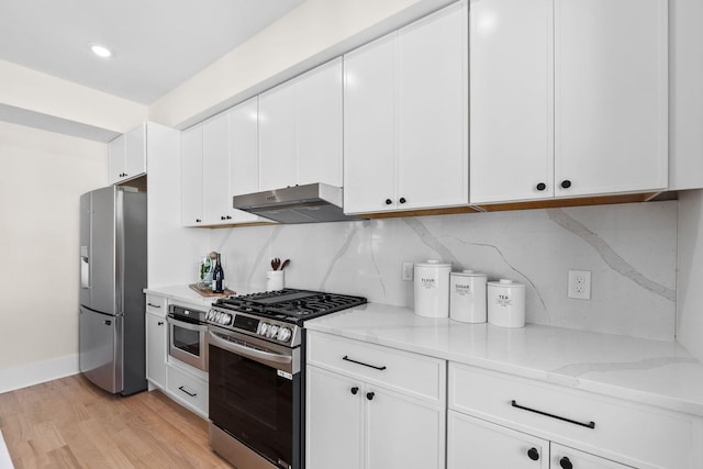 kitchen with stainless steel appliances, under cabinet range hood, light stone counters, light wood-style flooring, and recessed lighting