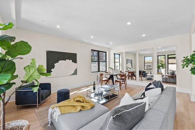 living room with plenty of natural light, recessed lighting, light wood-style floors, and baseboards