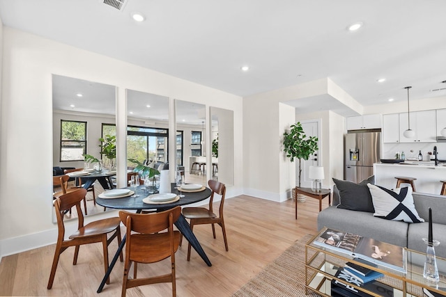 dining room featuring baseboards, light wood-style flooring, and recessed lighting