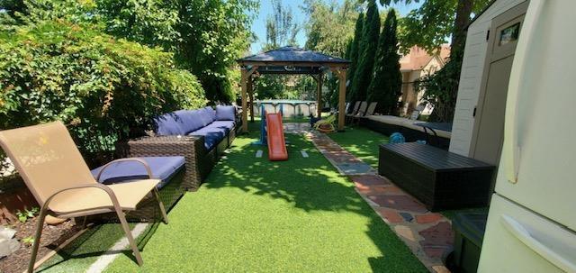 124 71st St, Guttenberg, NJ 07093 - view of grassy yard with outdoor lounge area and a gazebo