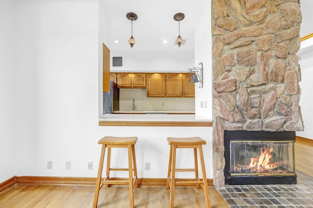 301 79th St Unit E4, North Bergen, NJ 07047 - kitchen featuring wood finished floors, a kitchen breakfast bar, pendant lighting, light countertops, and baseboards