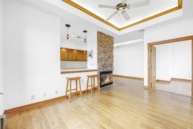 301 79th St Unit E4, North Bergen, NJ 07047 - unfurnished living room with a tray ceiling, ceiling fan, light wood-style flooring, a fireplace, and baseboards