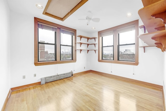 301 79th St Unit E4, North Bergen, NJ 07047 - spare room featuring a baseboard heating unit, ceiling fan, wood finished floors, baseboards, and recessed lighting