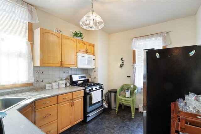 4007 Grand Ave, North Bergen, NJ 07047 - kitchen featuring appliances with stainless steel finishes, backsplash, light countertops, hanging light fixtures, and a sink