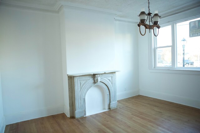 unfurnished living room featuring a chandelier, hardwood / wood-style flooring, and a healthy amount of sunlight