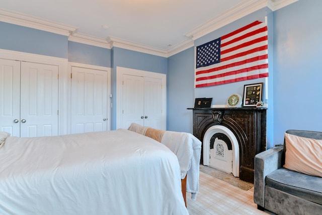 bedroom featuring ornamental molding and two closets