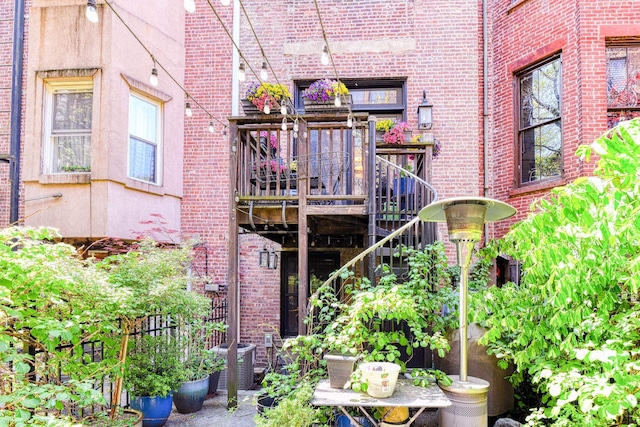 exterior space with stairs, cooling unit, and brick siding