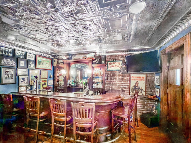 bar with an ornate ceiling, brick wall, and a bar