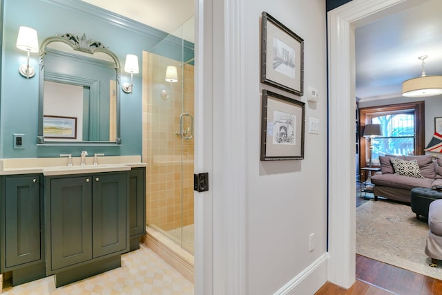 full bath featuring crown molding, vanity, baseboards, and a stall shower