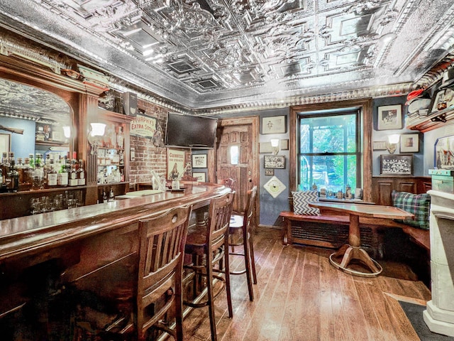 bar featuring a dry bar, an ornate ceiling, and hardwood / wood-style flooring