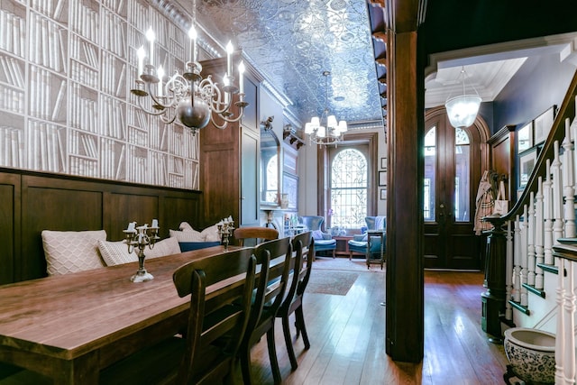dining room featuring an inviting chandelier, an ornate ceiling, ornamental molding, and stairs