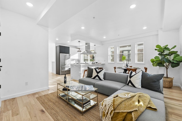 living room featuring light wood finished floors, recessed lighting, and baseboards