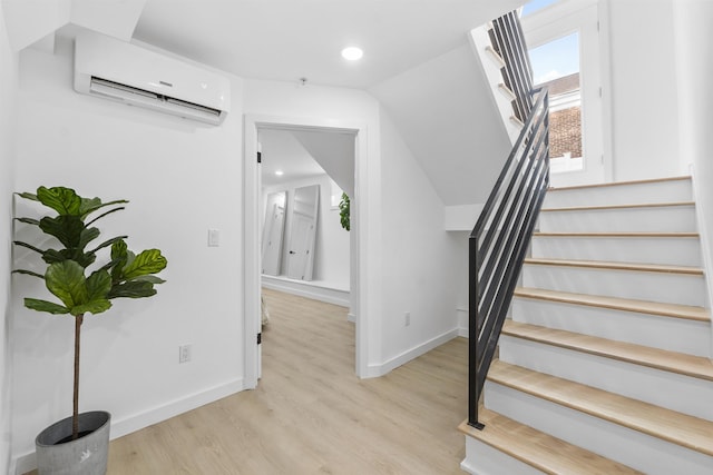 stairs featuring recessed lighting, baseboards, wood finished floors, and a wall unit AC