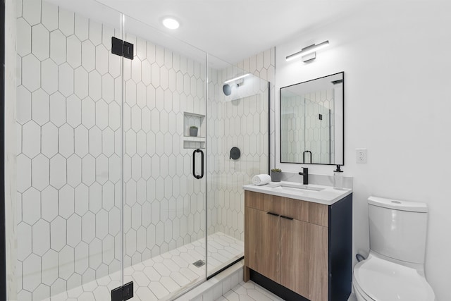 bathroom featuring vanity, a shower stall, and toilet