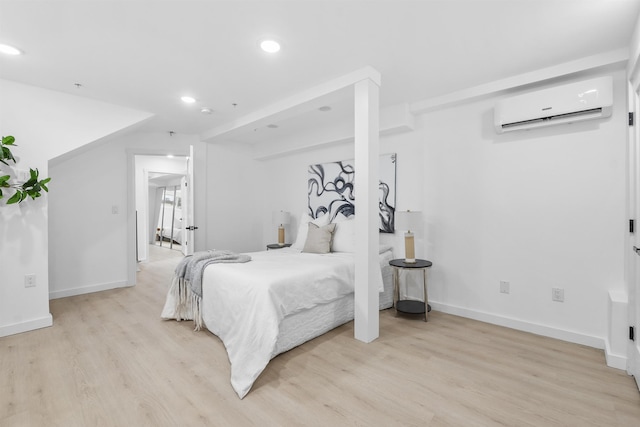 bedroom with recessed lighting, baseboards, light wood-type flooring, and a wall unit AC