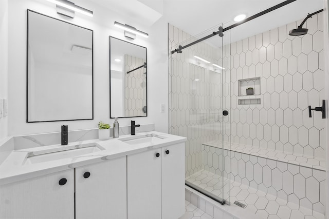 full bathroom featuring a sink, double vanity, and a shower stall