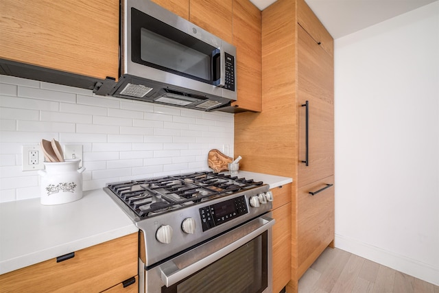 10 Provost St Unit 2405, Jersey City, NJ 07302 - kitchen with appliances with stainless steel finishes, light countertops, tasteful backsplash, and light wood-type flooring
