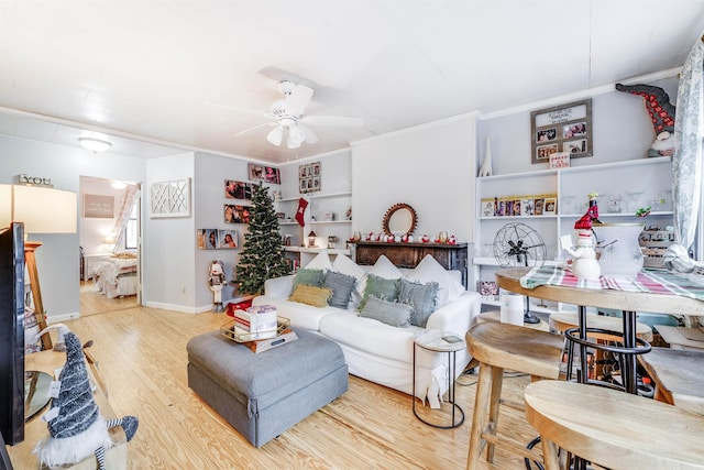 living room featuring ceiling fan, ornamental molding, and hardwood / wood-style flooring