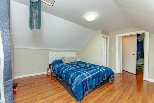 bedroom featuring hardwood / wood-style flooring and lofted ceiling