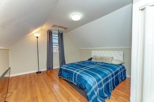bedroom featuring hardwood / wood-style floors and lofted ceiling