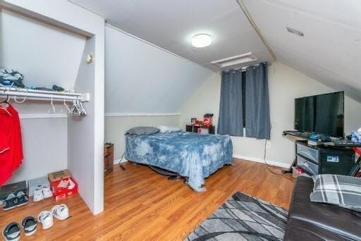 bedroom featuring hardwood / wood-style flooring and vaulted ceiling