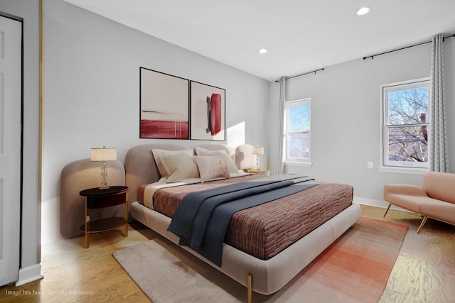 bedroom with multiple windows and light hardwood / wood-style flooring