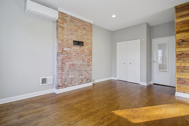 unfurnished bedroom with dark hardwood / wood-style floors, a closet, and a wall mounted AC