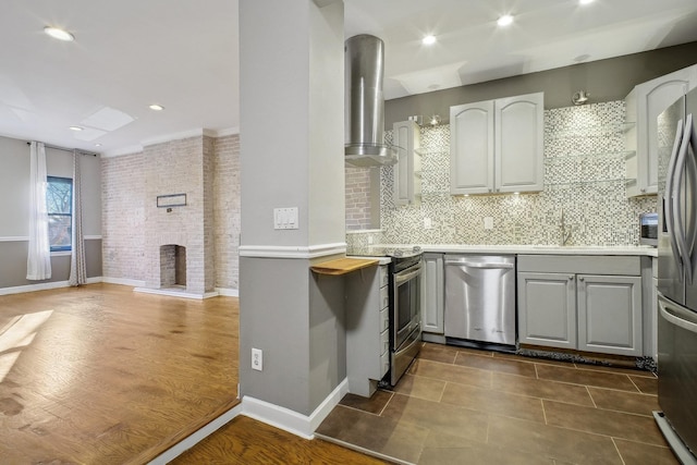 kitchen with gray cabinetry, backsplash, ventilation hood, dark tile patterned flooring, and stainless steel appliances