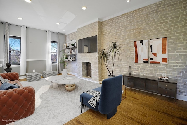 living room with dark hardwood / wood-style flooring, a brick fireplace, and brick wall