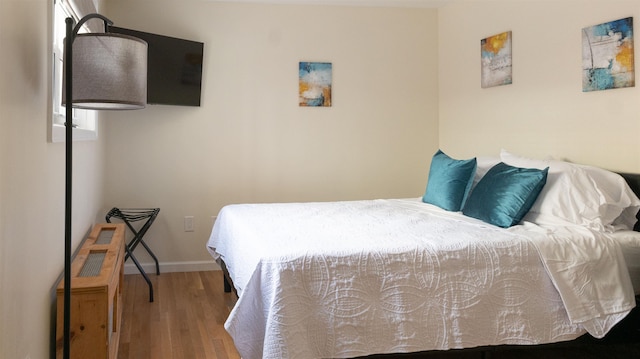 bedroom with baseboards and wood finished floors