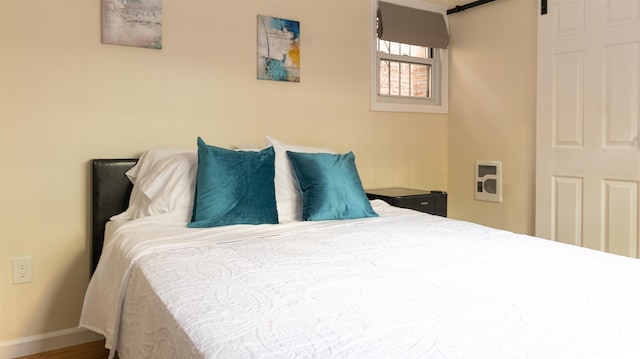 bedroom with baseboards and a barn door