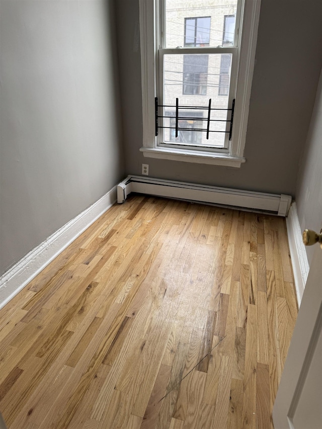 69 Jewett Ave, Jersey City, NJ 07304 - unfurnished room with baseboard heating, wood finished floors, and baseboards