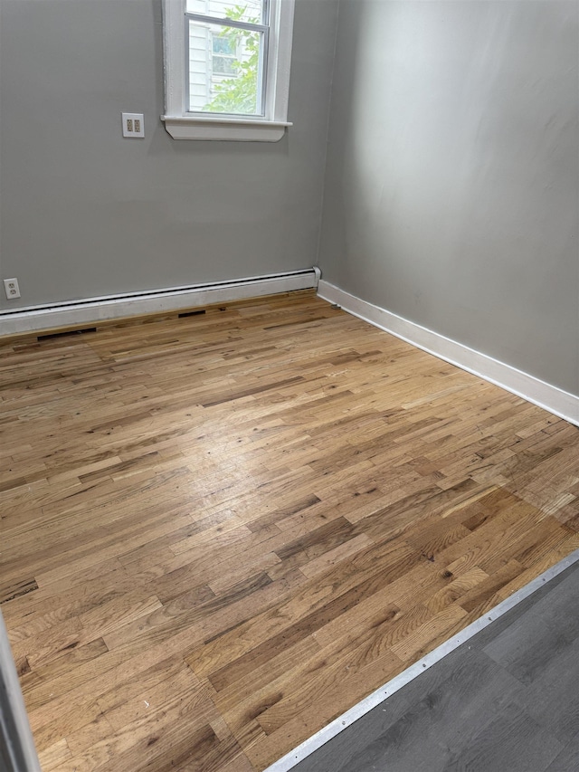 69 Jewett Ave, Jersey City, NJ 07304 - unfurnished room featuring wood finished floors, baseboards, and a baseboard heating unit