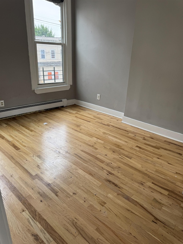 69 Jewett Ave, Jersey City, NJ 07304 - spare room featuring light wood finished floors, a baseboard radiator, and baseboards
