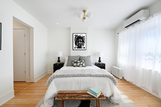 372 Webster Ave, Jersey City, NJ 07307 - bedroom with an AC wall unit, light wood-style flooring, and radiator heating unit