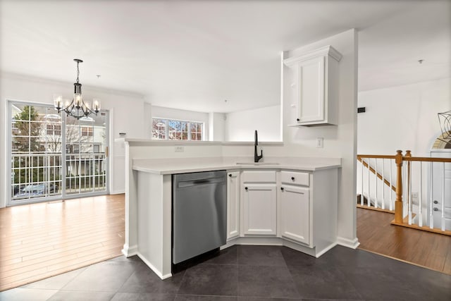 kitchen featuring white cabinets, stainless steel dishwasher, a sink, an inviting chandelier, and light countertops
