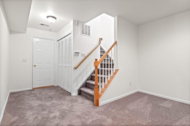 stairs with baseboards, visible vents, and carpet