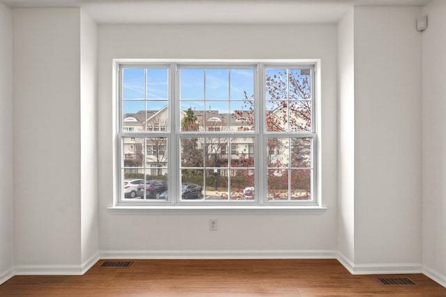 details featuring baseboards, wood finished floors, and visible vents