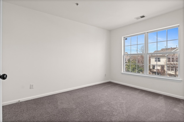 unfurnished room with visible vents, baseboards, and carpet flooring