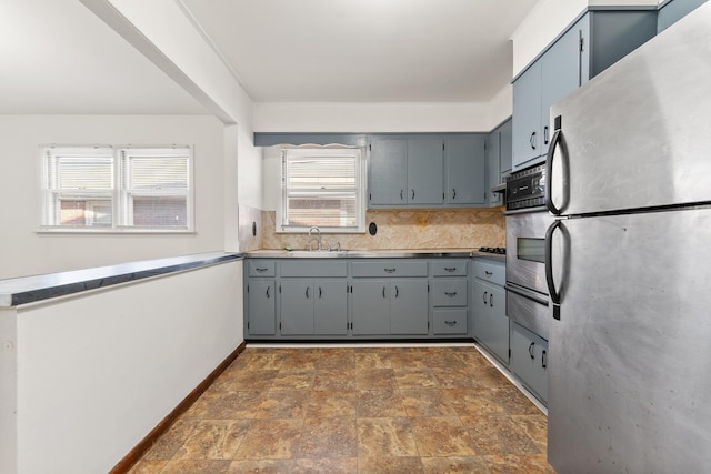 kitchen featuring sink, wall oven, tasteful backsplash, stainless steel fridge, and gray cabinets