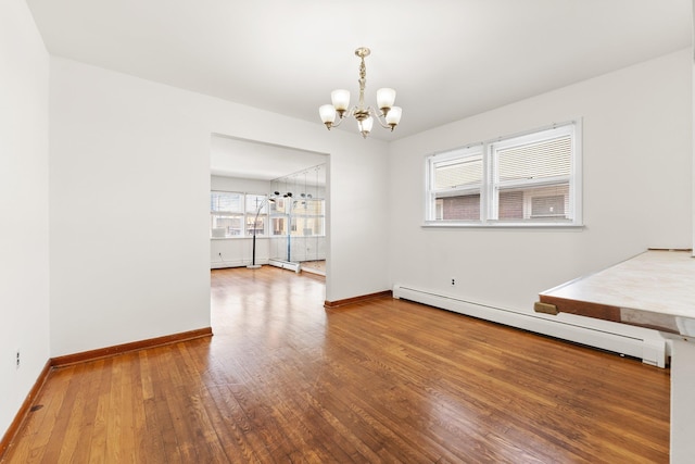 unfurnished dining area with hardwood / wood-style flooring, a notable chandelier, and a baseboard heating unit