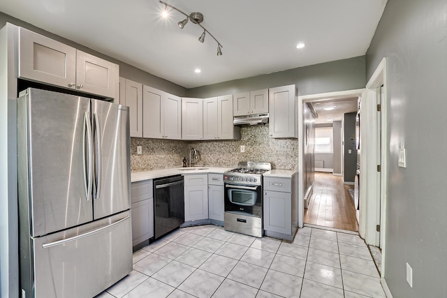 kitchen with stainless steel appliances, sink, tasteful backsplash, gray cabinetry, and light tile patterned floors