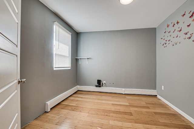 spare room with a baseboard radiator and light hardwood / wood-style flooring